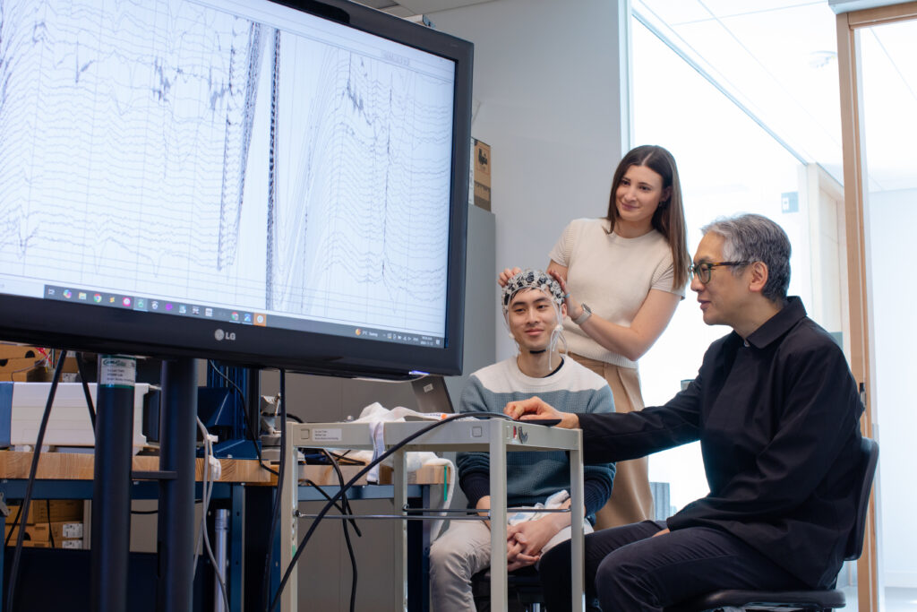 A group of researchers view a chart on a large screen
