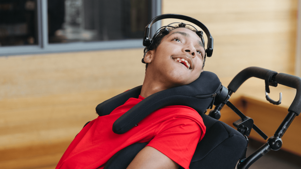 A young person uses a brain computer interface headset to paint a picture