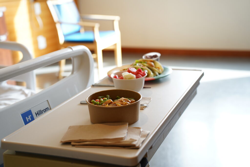 Bowls of food placed on a table in a hospital room.