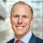DB An adult wears a suit in front of a white background