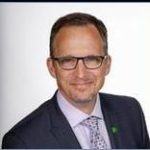Justin Flowerday An adult wears a suit in front of a white background