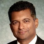 Nitin Kawale An adult wears a suit in front of a grey background
