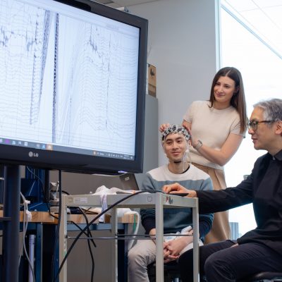 A group of researchers view a chart on a large screen