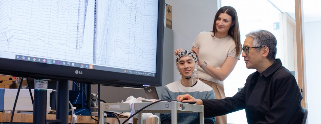 A group of researchers view a chart on a large screen